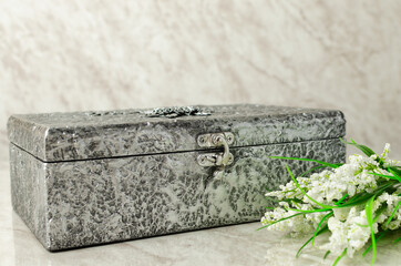 Caja decorada como cofre antiguo con textura metalica plateada.