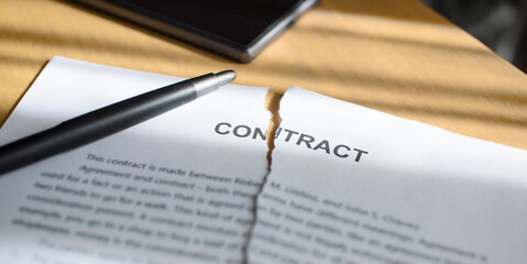 A torn contract on the table.  Torn document on the desk.