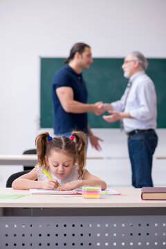 Young Parent, Old Male Teacher And Little Girl In The Classroom