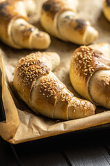 Salted croissant bun roll on baking paper. Homemade pastry.