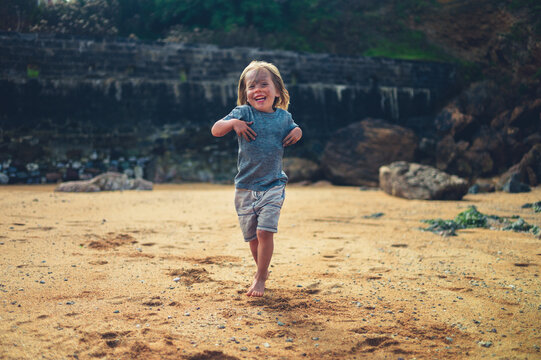 Little preschooler playing on the beach