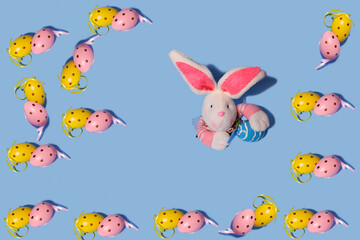 Easter background. Easter eggs pattern. In the center, a rabbit peeks out of torn paper. Horizontal, free space.