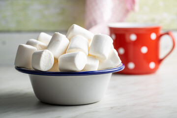 White sweet marshmallows candy in bowl on kitchen table.