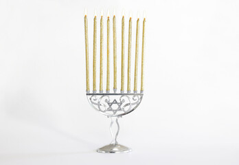 religion image of jewish holiday Hanukkah with white menorah (traditional candelabra) and gold candles isolated over white background