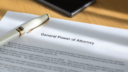 A General Power of Attorney on the desk. A document an a pen on the table.