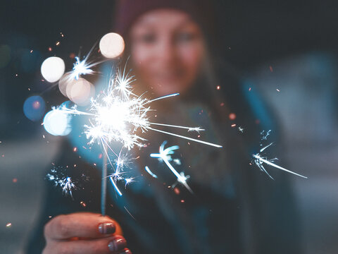 Close-up Of Woman Holding Sparkler Burning At Night
