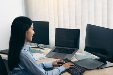 Asian young female programmer working developer programing on a computer code at office.