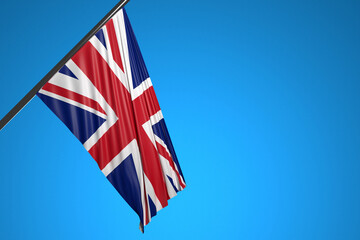 3D illustration of the national flag of United Kingdom on a metal flagpole fluttering against the blue sky.Country symbol.