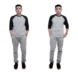 Young handsome man wearing black grey raglan t shirt isolated on plain background