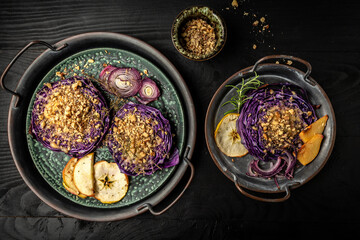 Vegan roasted red cabbage steaks with nuts, quince, onions and apples Top view, flat lay