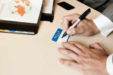 Businessman writing on name tag in office
