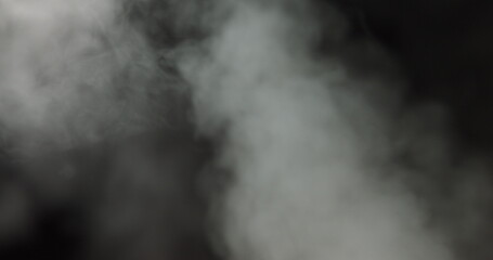 Atmospheric smoke VFX overlay element. Haze background. Smoke in slow motion on black background. White smoke slowly floating through space against black background. Mist effect. Fog effect.