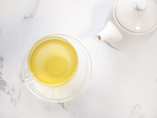 Obraz na płótnie Canvas 透明耐熱グラスに急須で注がれた緑茶・日本茶を家で飲む様子。