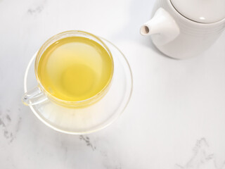 Obraz na płótnie Canvas 透明耐熱グラスに急須で注がれた緑茶・日本茶を家で飲む様子。
