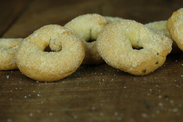 Ciambelle e biscotti artigianali su sfondo in legno. Prodotto da forno artigianale. Biscotti con...