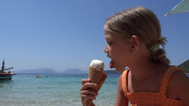 Girl Eating Ice Cream on Beach at Sunset, Kid Playing on Seashore, Blonde Child Watching Sea Waves at Ocean in Summer Vacation