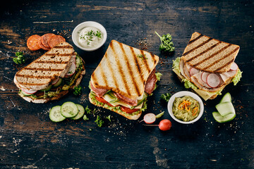 Sandwiches with salami, ham, guacamole and cheese