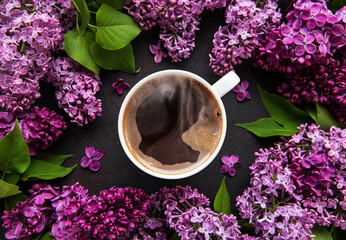 Obraz na płótnie Canvas Lilac and cup of coffee in flat style on black concrete background.
