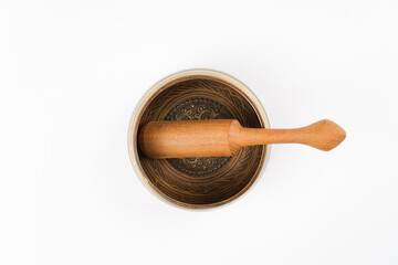 Singing bowl with wooden stick on white background. Meditation, yoga, self-development concept. Top...