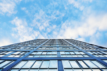 Looking up at mirrored glass side of high rise building