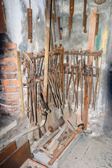 Old forge with tools hanging on a wall