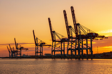 Beautiful sunset at a seaport with container cranes