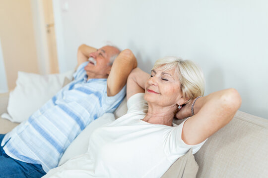 Senior aged couple relaxing on comfortable sofa together breathing fresh air at home, calm old mature man and woman enjoying no stress free weekend peaceful rest having healthy daytime nap on couch