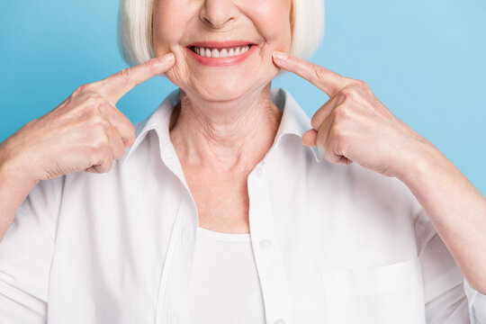 Cropped closeup photo of old lady showing white teeth healthy smile dental whitening veneers isolated on vibrant blue color background