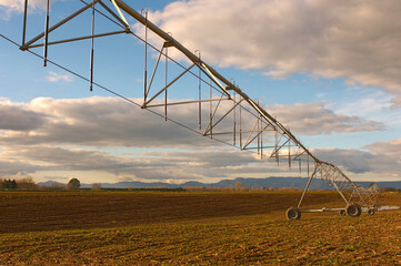 Moveable Irrigation boom sprinkler system in large ploughed field