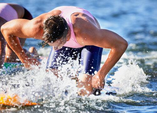 Team of male surf lifeguards training and paddling flat out