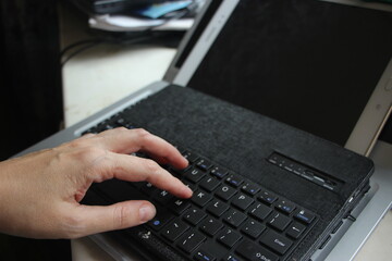 Close-up of typing on laptop keyboard of young man hands. Business trading copywriting concept