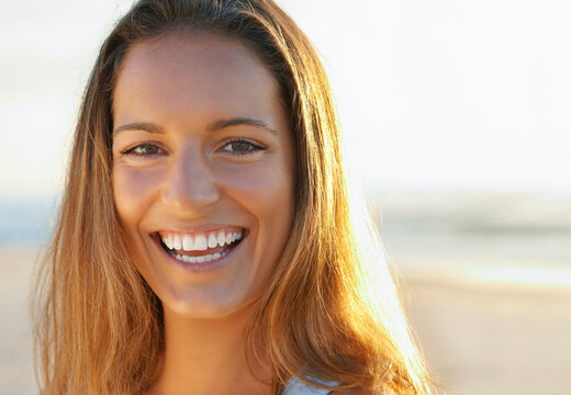 Portrait of healthy beautiful young woman at the beach and smiling