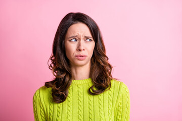 Fototapeta premium Photo of disgusted anxious girl grimace look side empty space wear green pullover isolated pink color background