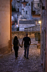 Couple during a walk on Cobblestone street in the Sassi di Matera a historic district in the city of Matera. Basilicata. Italy