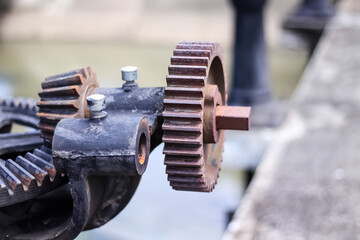 Vintage metal mechanical gear on the floodgate , old cogwheel background