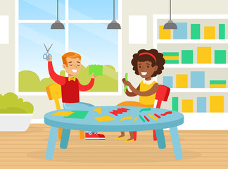 Cute Creative Kids Sitting at Table Cutting Color Paper with Scissors, Smiling Boy and Girl Crafting Together in Kindergarten Cartoon Vector Illustration