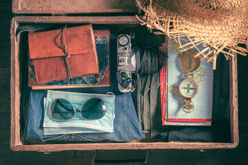 Disposable mask and full suitcase as travel restrictions. Covid-19 restriction