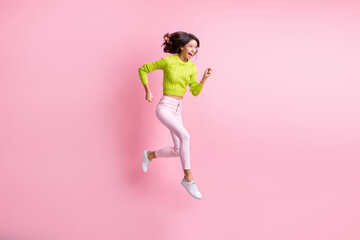 Fototapeta na wymiar Full length photo of adorable sweet wavy lady wear green sweater jumping running fast isolated pastel pink color background