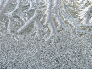 Natural ice pattern background with beautiful frosty crystals on the glass. Abstract Christmas composition with hoarfrost ornament for design, copy space.