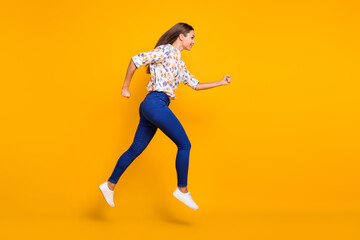 Fototapeta na wymiar Photo portrait full body side view of running girl jumping up isolated on vivid yellow colored background