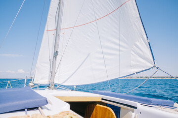 Yacht sailing in sea on sunny day, close-up.