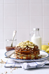 Delicious hot banana pancakes with caramel sauce and nuts.