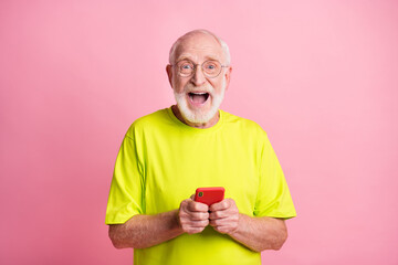 Portrait of impressed handsome old man open mouth unexpected news lime clothing isolated on pink...