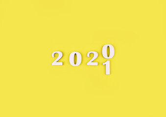Close-up of wooden numbers 2021 on yellow background. Change year 2020 to 2021. Holidays content