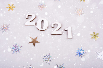 Close-up of wooden numbers 2021 on grey background with stars. Holidays content