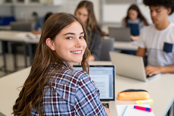 Happy smiling college girl studying on laptop - obrazy, fototapety, plakaty