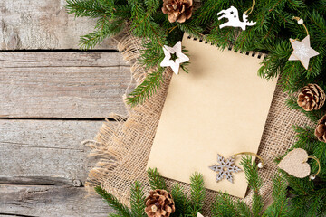 Christmas or new Year background with an open blank Notepad, spruce branches and Christmas...