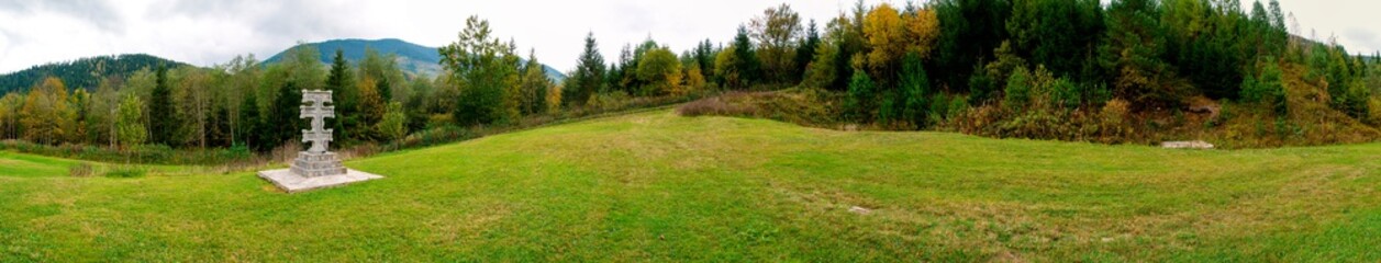 panorama of a mountain landscape with a monument of the cross