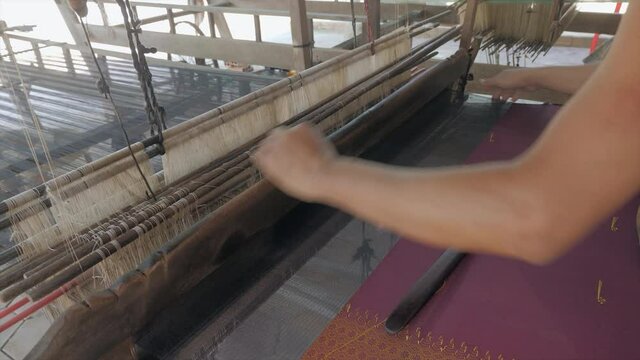 close up of a person weave traditional silk cloth with beautiful patterns 