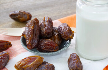 Ramadan food, sweet dried dates fruit and glass of milk on wooden table